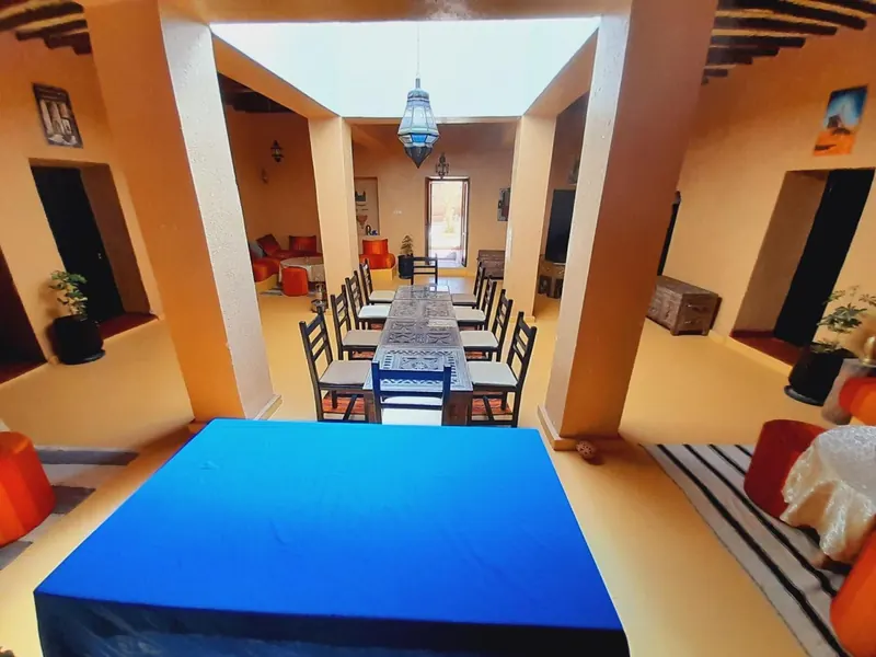 The long dining table with a blue cloth, in the covered patio