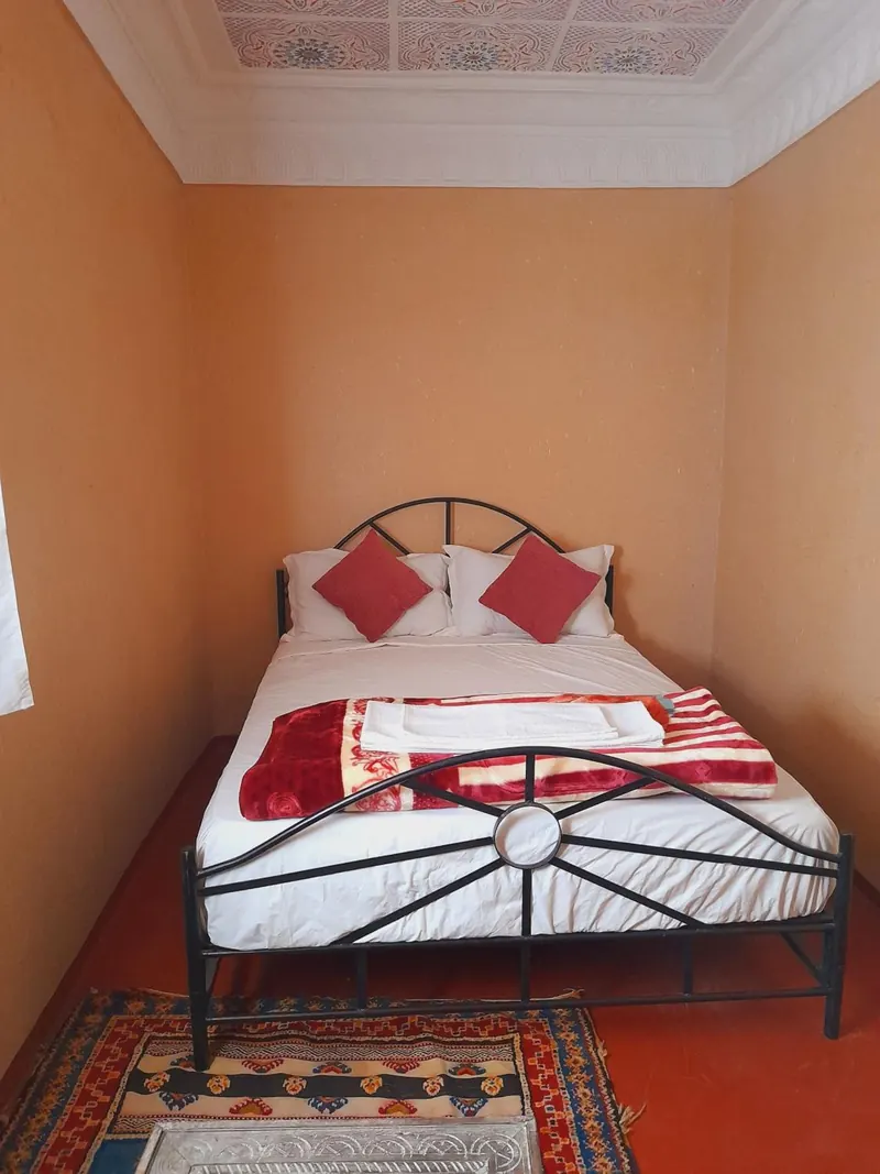 Double or Twin Room: a double bed with red cushions
