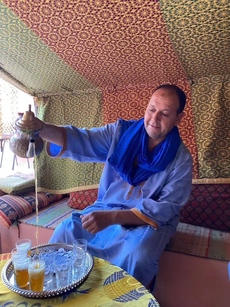 Azzeddine, the host, pouring mint tea in the tent lounge